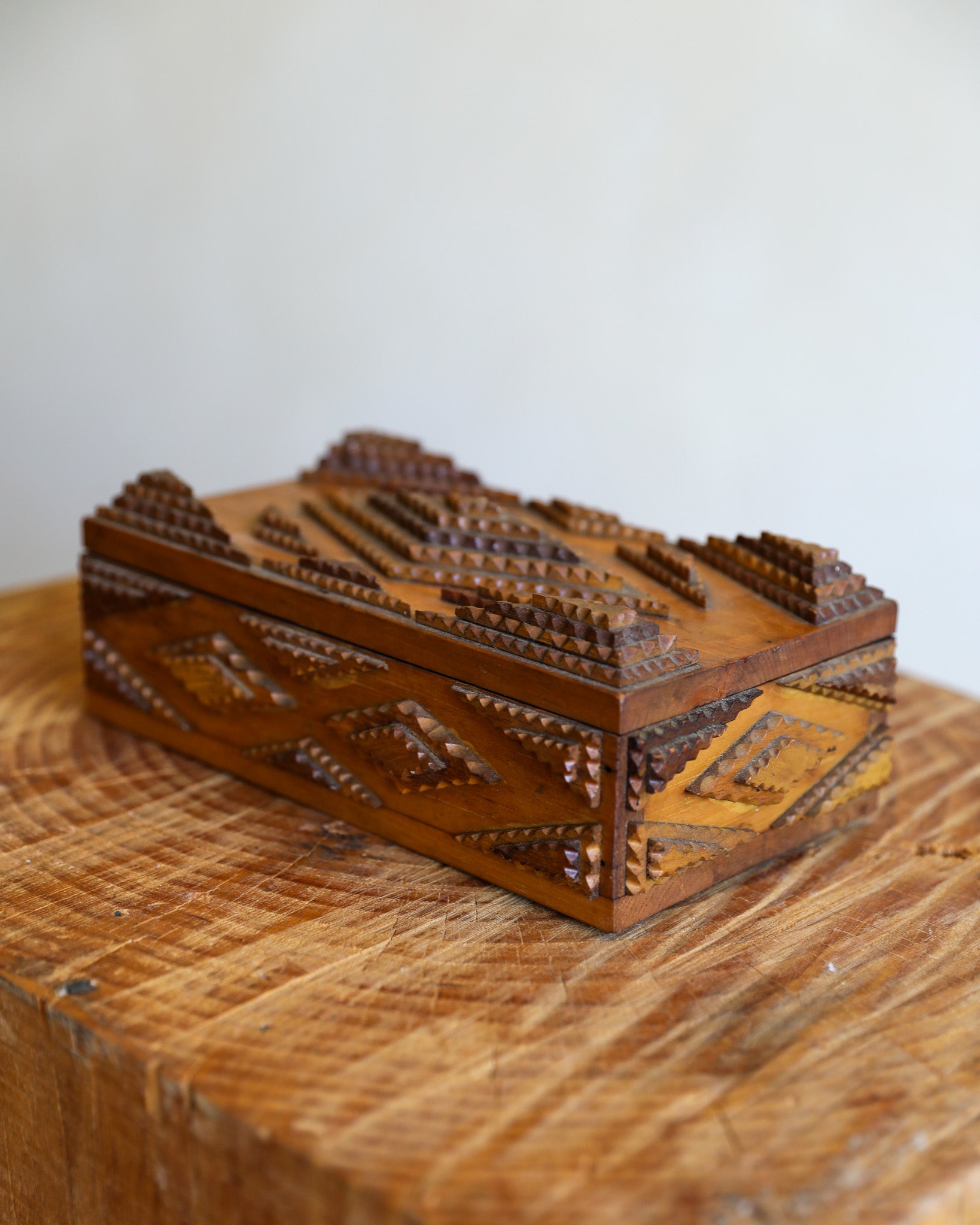 tramp art box on wood stump
