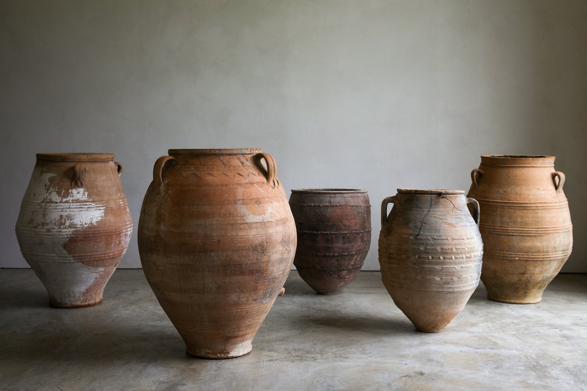 antique turkish urn grouping in studio with natural patinas and etched detailing