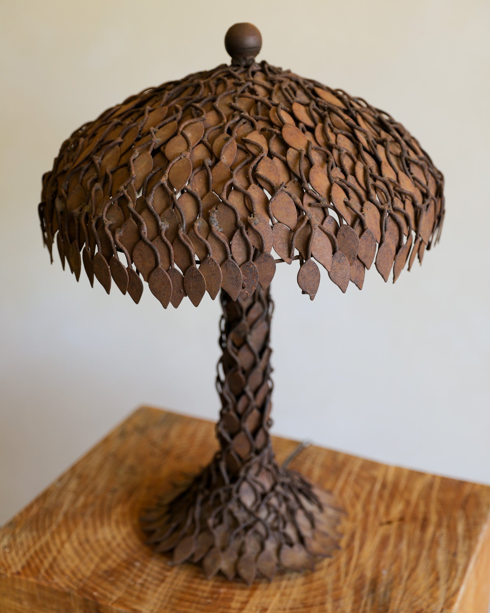 textural rusted metal brutalist table lamp detail on wood stump