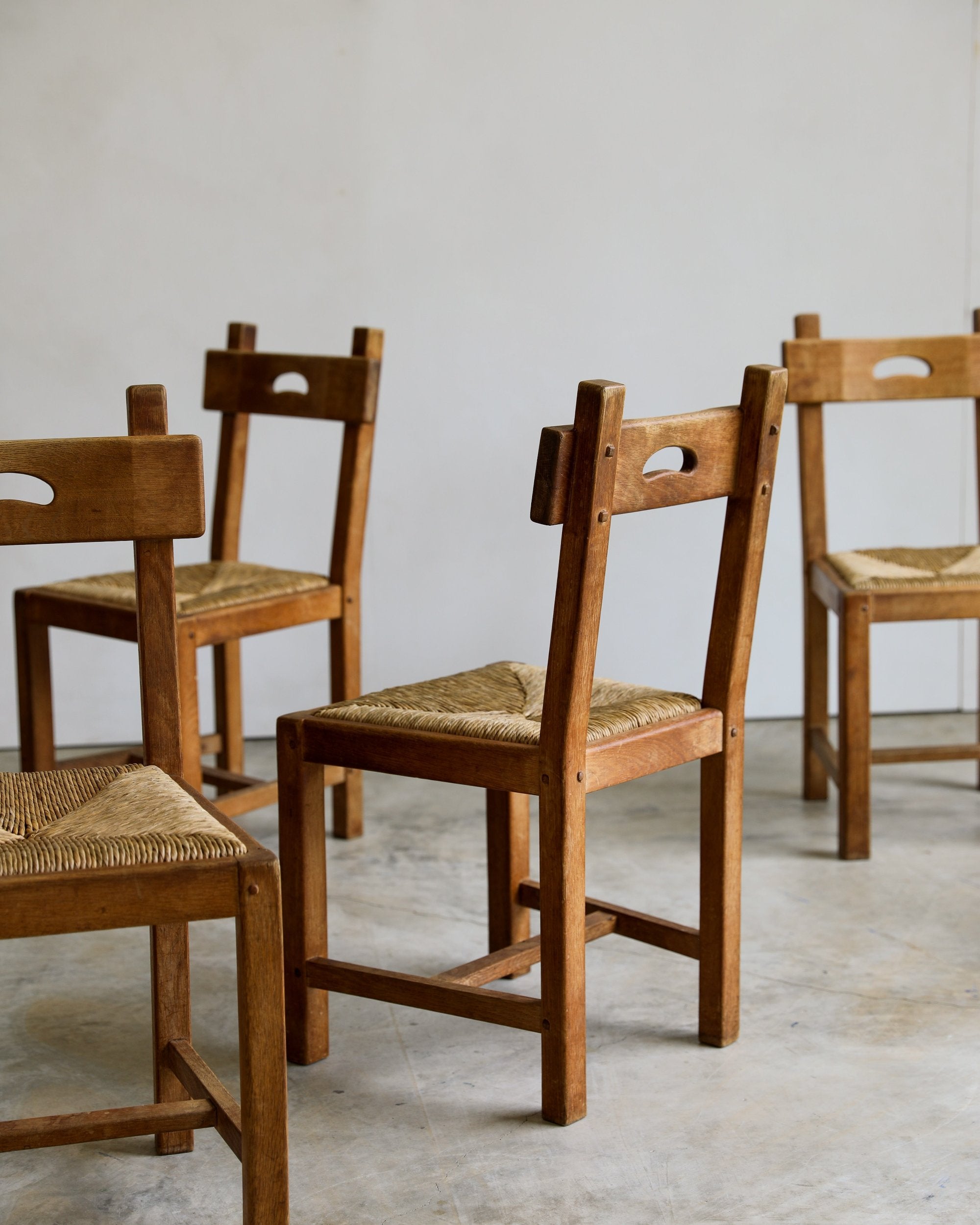 French Brutalist rush and wood vintage dining chair scattered group