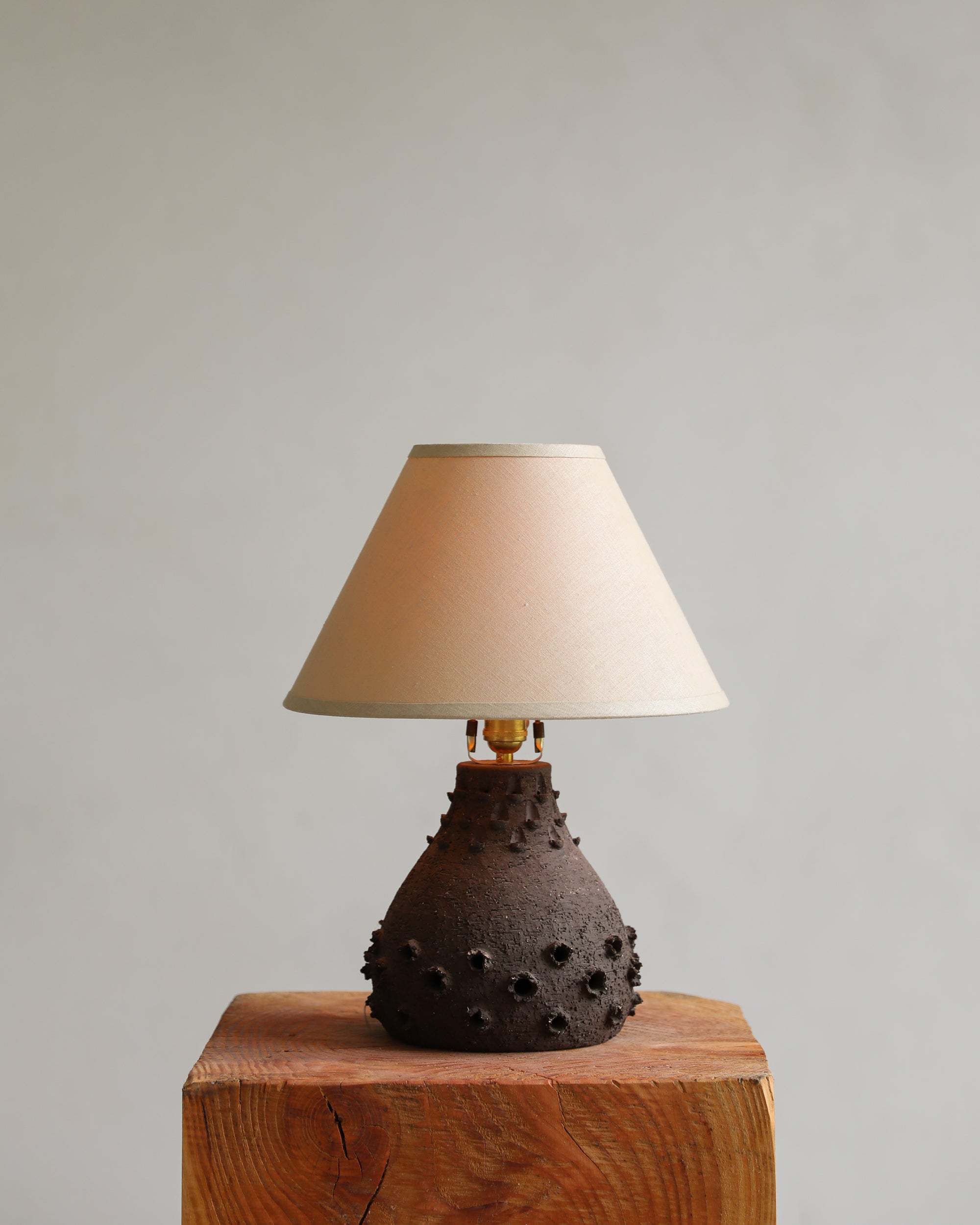 vintage brutalist table lamp ceramic with linen shade light on detail