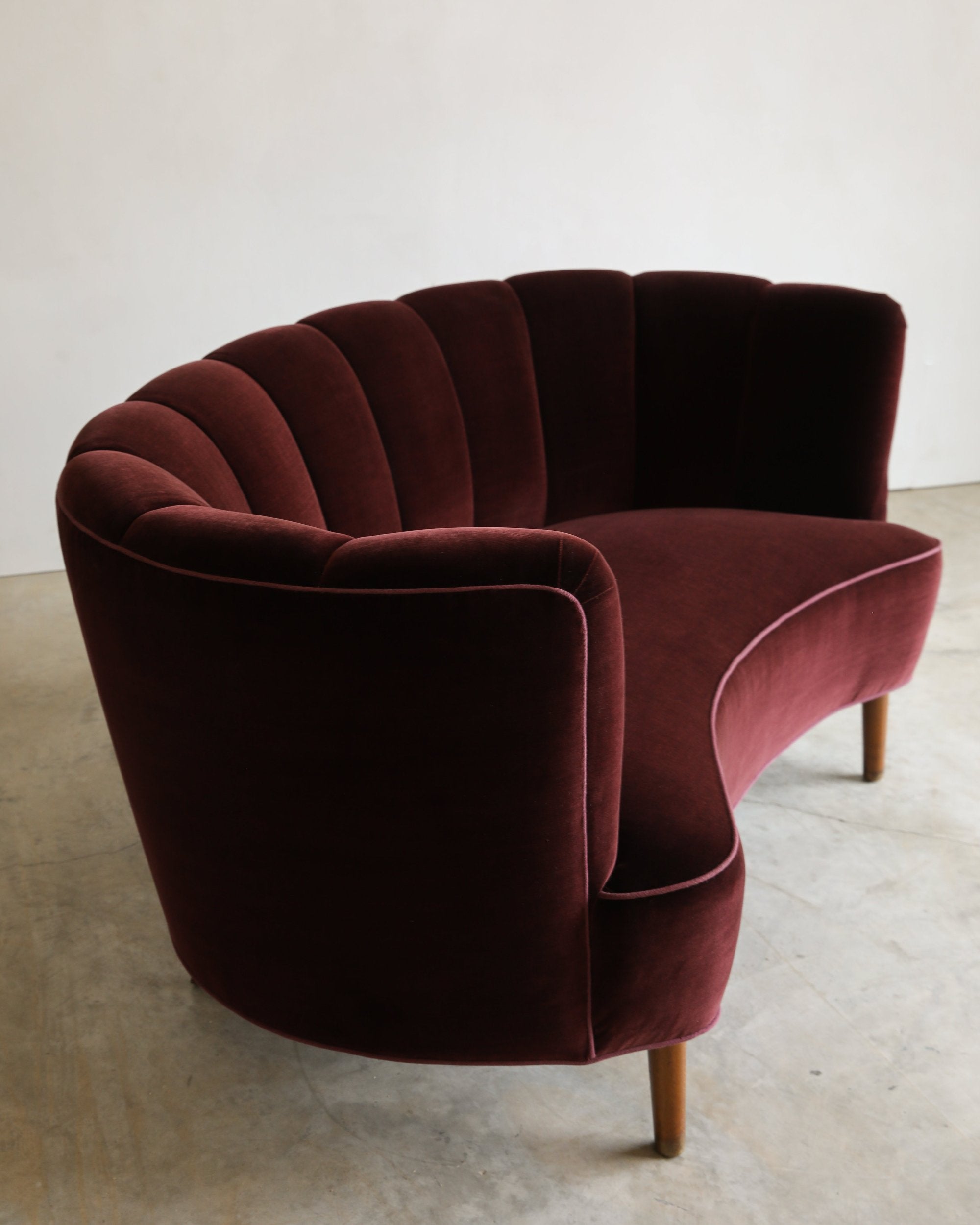 vintage reupholstered velvet channel tufted settee sofa with wooden feet three quarter closeup detail