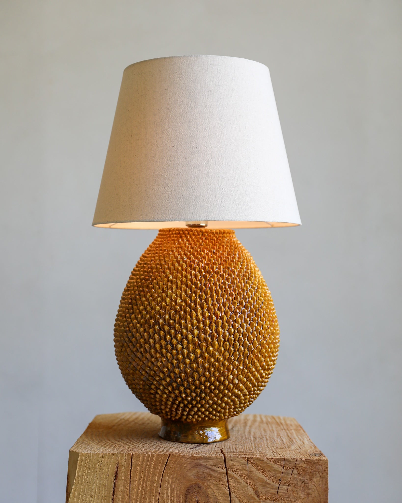 golden yellow amarillo glazed terracotta ceramic textural Mexican table lamp with linen shade front view light on