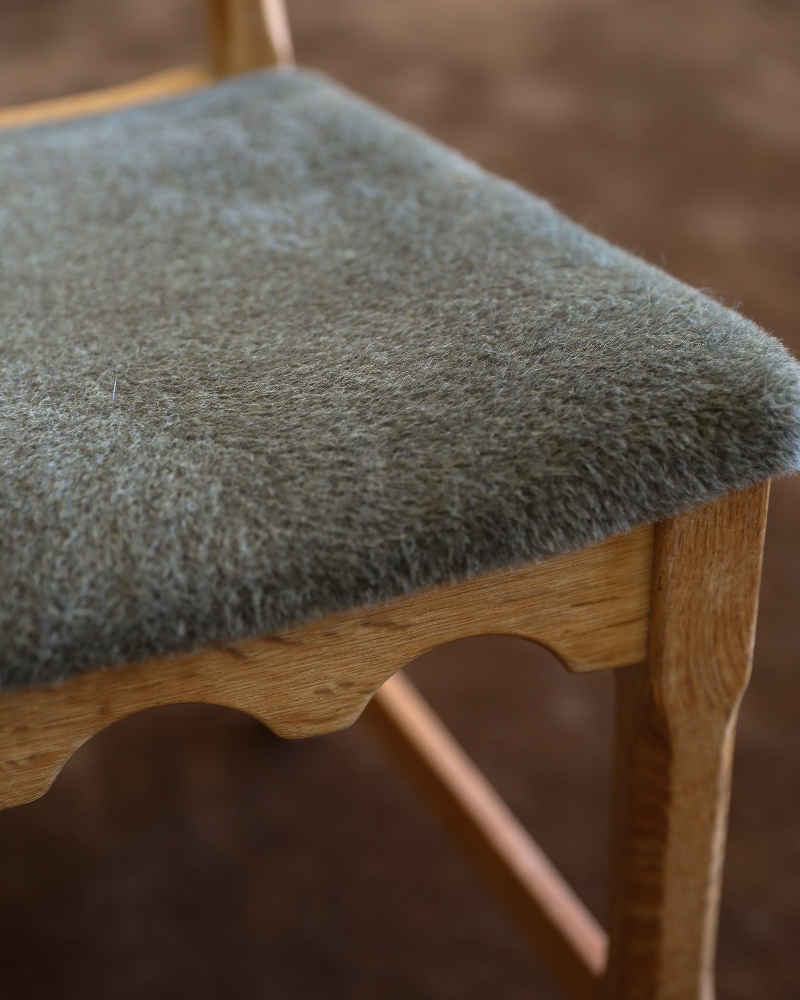 detail of pale green suri alpaca wool seat on carved wood chair