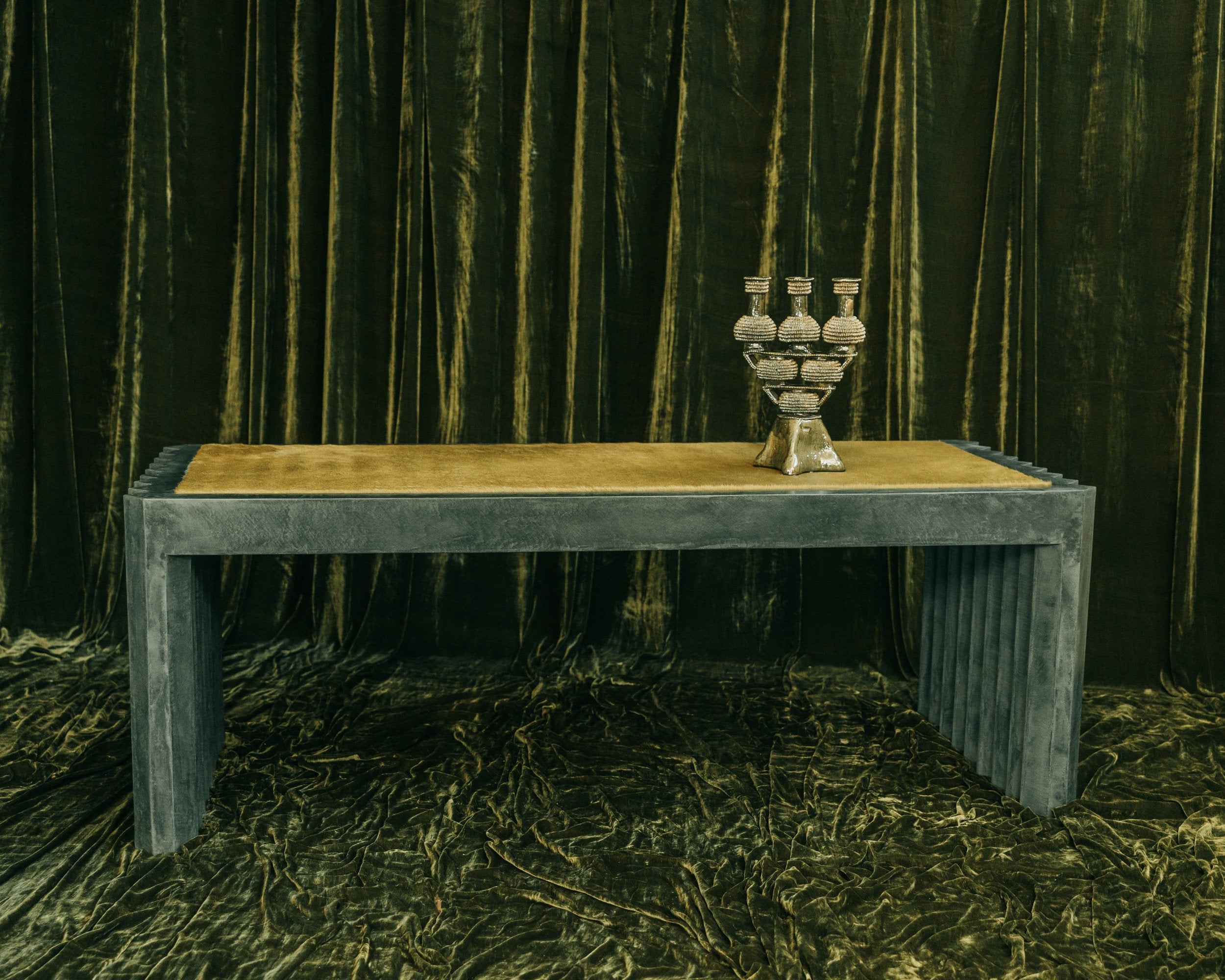 haus of hommeboys green faceted plaster desk with green hair on hide inset on green velvet backdrop