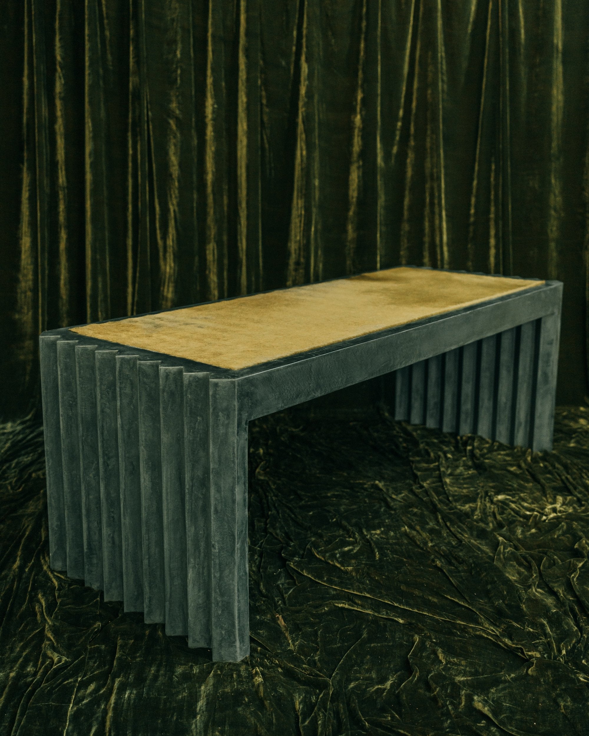 haus of hommeboys green faceted plaster desk with green hair on hide inset on green velvet backdrop