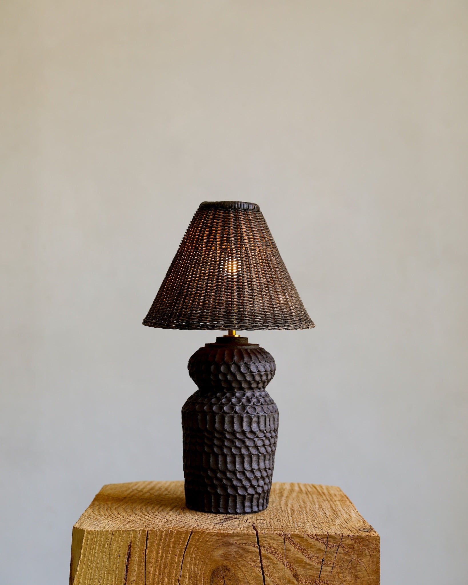 unglazed Fielding Clayworks handmade ceramic textured table lamp with custom wicker shade and raw brass fittings on detail