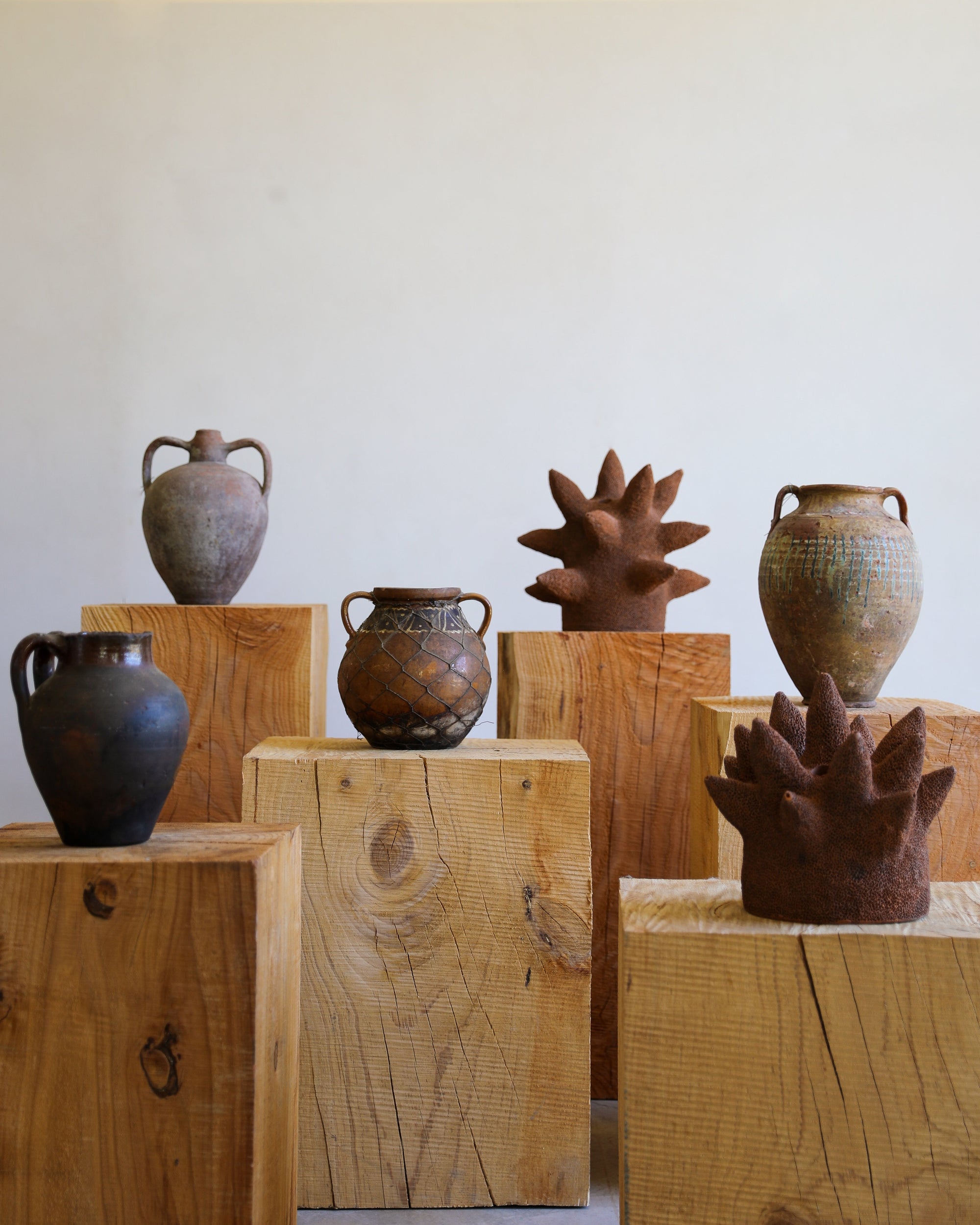 terracotta sculptures in grouping with antique terracotta urns and pots both glazed and unglazed