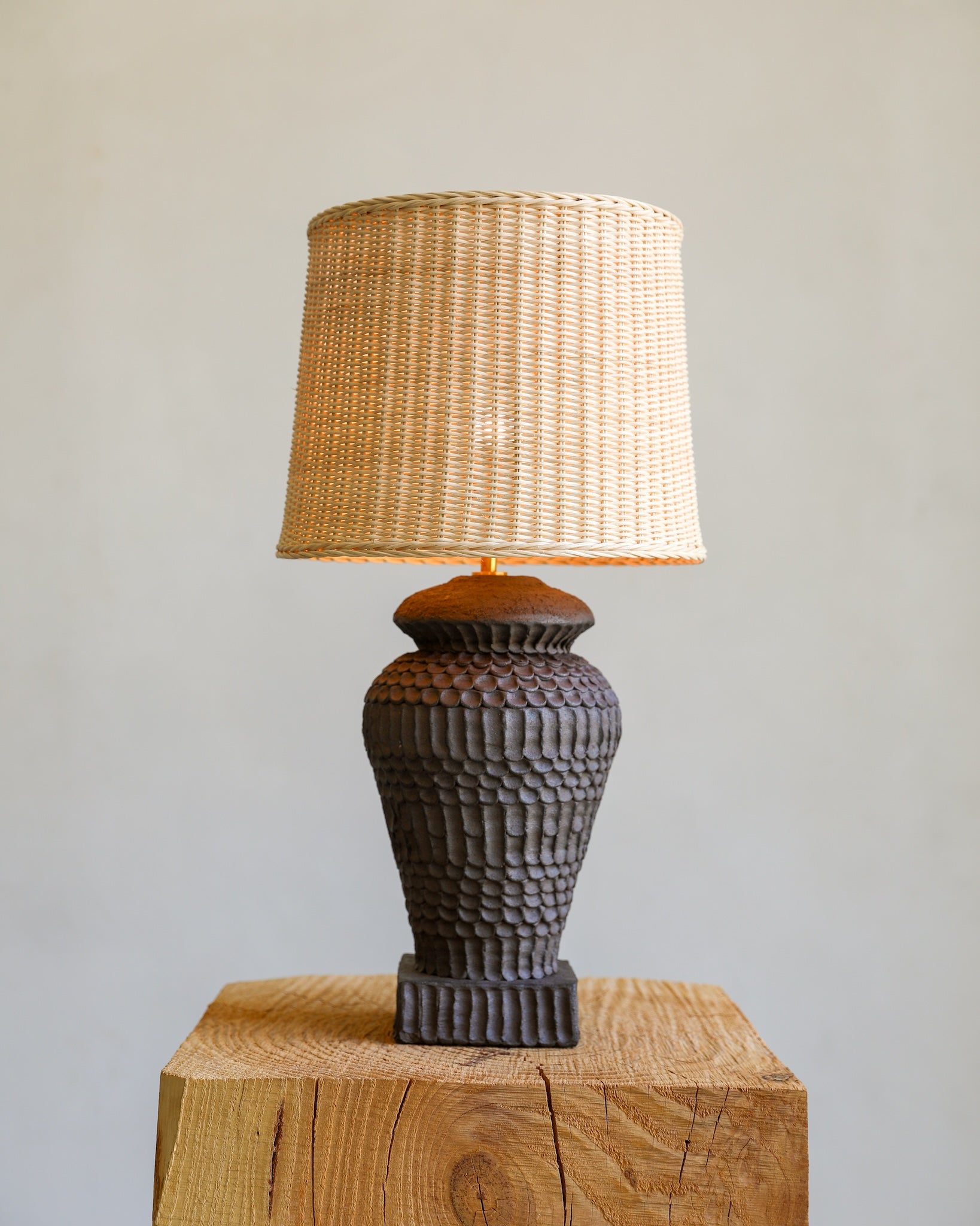 unglazed Fielding Clayworks handmade ceramic textured table lamp with custom wicker shade and raw brass fittings on detail