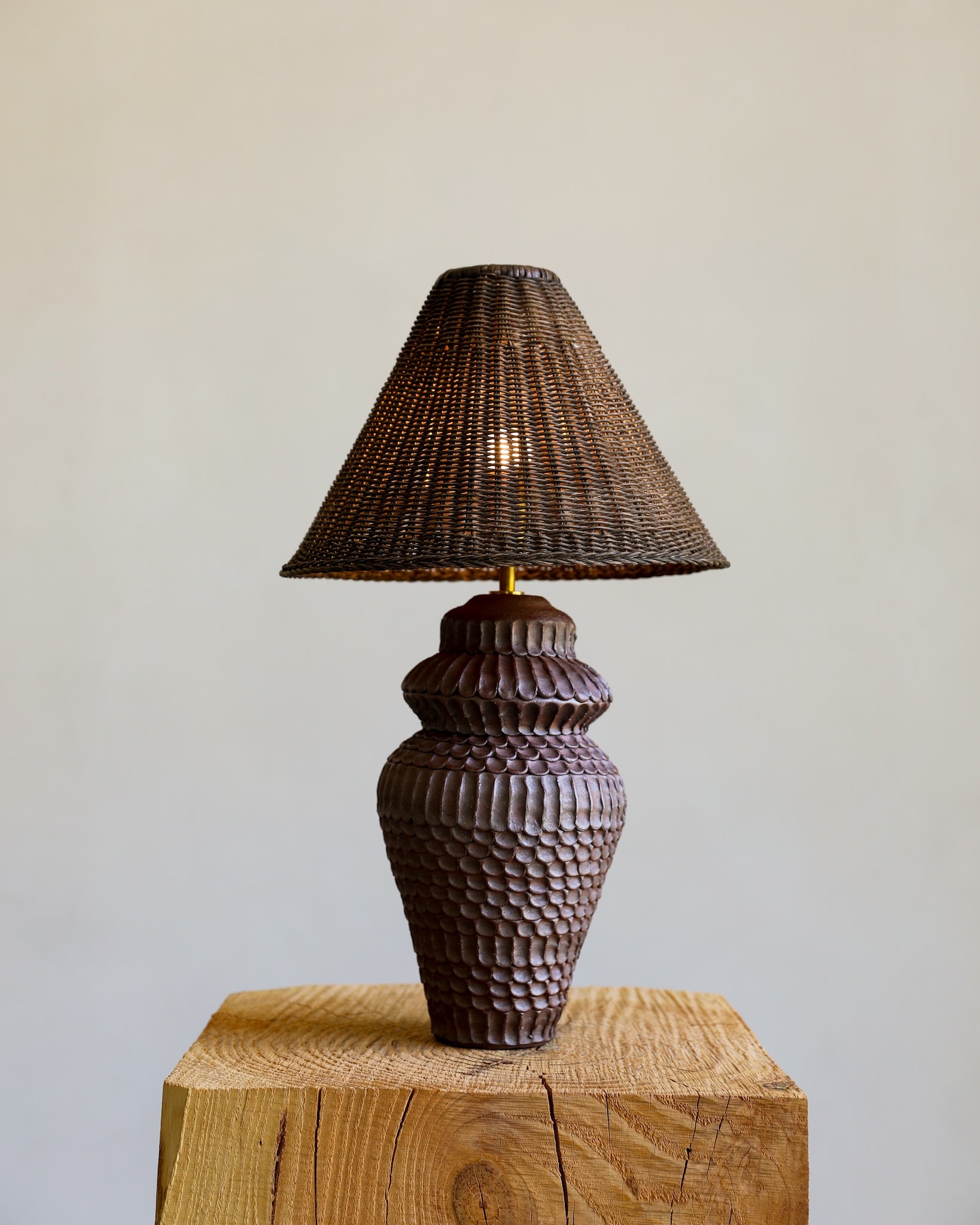 unglazed Fielding Clayworks handmade ceramic textured table lamp with custom wicker shade and raw brass fittings on detail