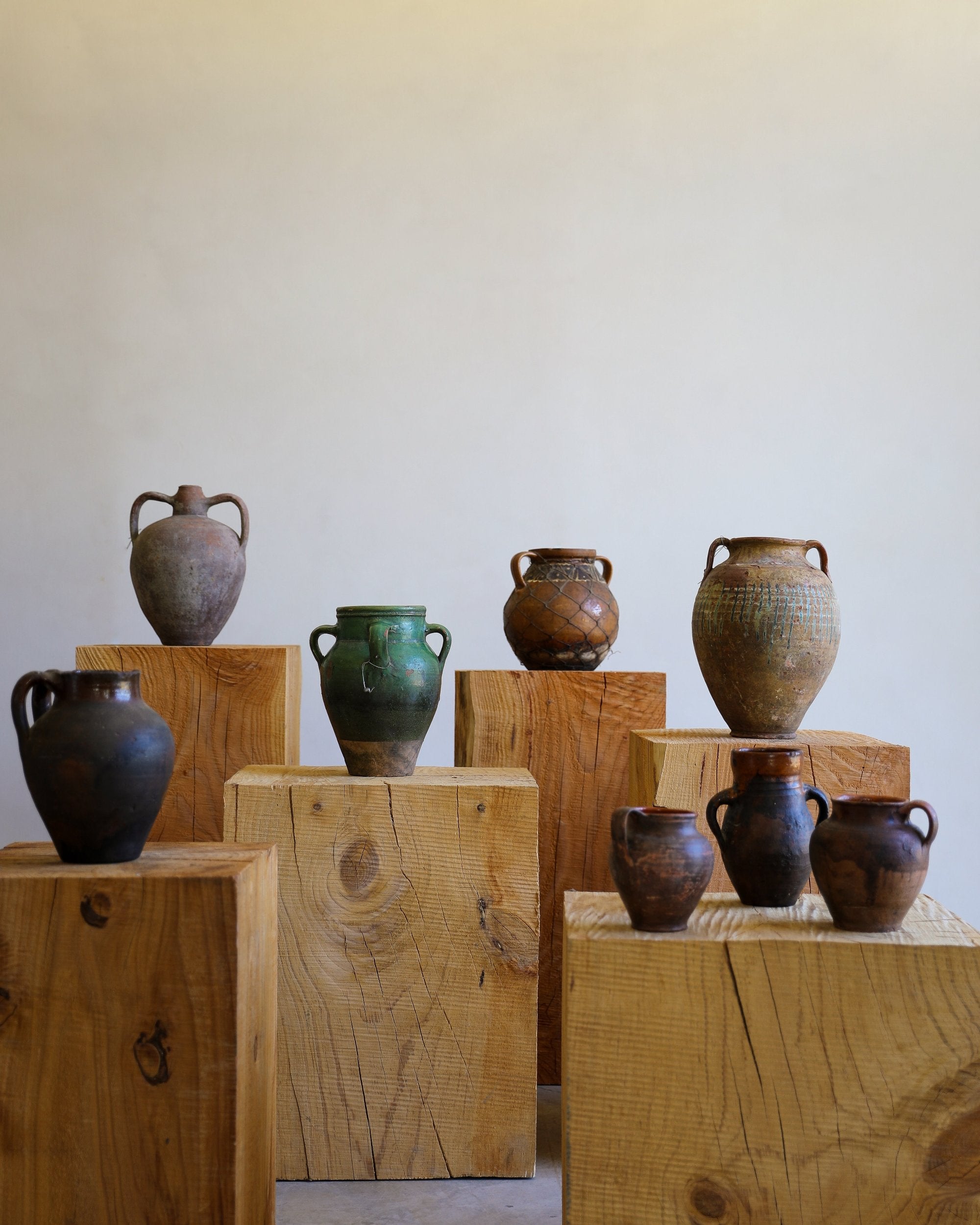 mixed group of antique pots terracotta glazed various sizes different colors and patinas on wooden pillars