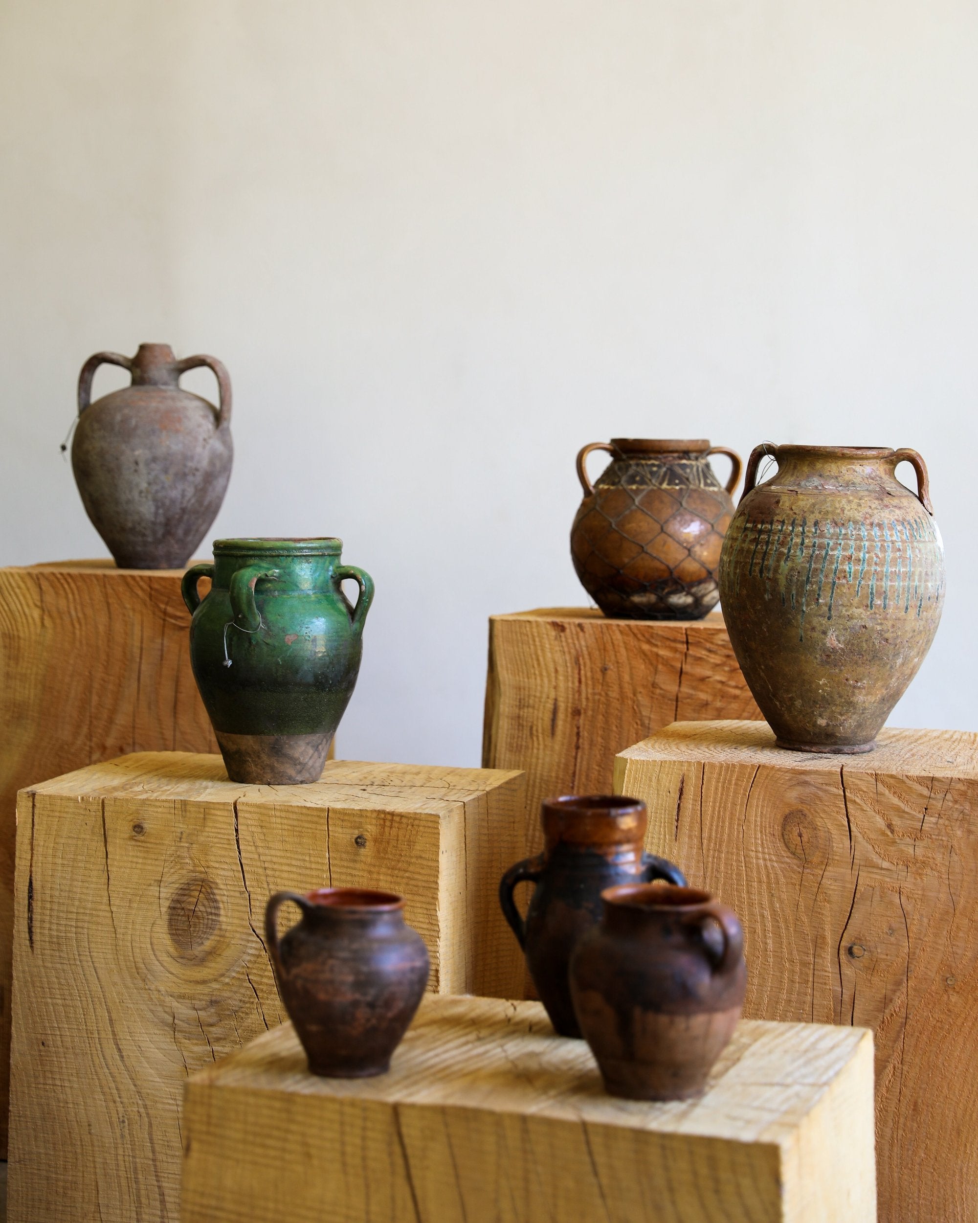 mixed group of antique pots terracotta glazed various sizes different colors and patinas on wooden pillars